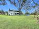 House with large backyard, featuring a spacious lawn and mature trees at 92 Wood Hall Dr, Mulberry, FL 33860