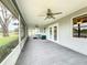 Spacious screened porch with ceiling fans and outdoor furniture, overlooking a lush backyard at 92 Wood Hall Dr, Mulberry, FL 33860