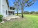 Landscaped backyard with patio, large trees, and expansive lawn at 92 Wood Hall Dr, Mulberry, FL 33860