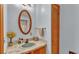 Small bathroom with wooden vanity and oval mirror at 4264 Stafford Dr, Winter Haven, FL 33880