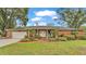 Brick ranch house with a covered porch, well-maintained landscaping, and a two-car garage at 4264 Stafford Dr, Winter Haven, FL 33880