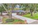 Brick house with a large front yard and long driveway, surrounded by mature trees at 4264 Stafford Dr, Winter Haven, FL 33880