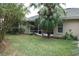Spacious backyard with grassy lawn and mature palm tree, providing ample privacy at 108 Lake Region N Blvd, Winter Haven, FL 33881