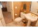 Small bathroom with pedestal sink, toilet, and decorative wallpaper at 108 Lake Region N Blvd, Winter Haven, FL 33881