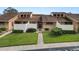Tan two-story condo building with grassy landscaping and walkways at 5225 Imperial Lakes Blvd # 22, Mulberry, FL 33860