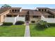 Tan two-story condo building with grassy landscaping and walkways at 5225 Imperial Lakes Blvd # 22, Mulberry, FL 33860