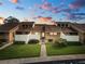 Tan two-story condo building with grassy landscaping and walkways at sunset at 5225 Imperial Lakes Blvd # 22, Mulberry, FL 33860