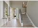 Modern entryway showcasing a stylish console table and a sleek staircase with metal railings at 7004 Oakwood St, Davenport, FL 33837