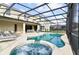 Relax in the screened-in pool and spa with lounge chairs at 7004 Oakwood St, Davenport, FL 33837