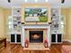Inviting living room featuring a fireplace, built-in shelving, and hardwood floors at 2731 Coventry Ave, Lakeland, FL 33803