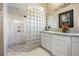 Bathroom with a walk-in shower, double vanity, and glass block feature at 4510 Roundup Dr, Polk City, FL 33868