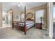 Main bedroom with a post bed, ensuite bathroom access, and a ceiling fan at 4510 Roundup Dr, Polk City, FL 33868