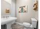 Clean bathroom with pedestal sink, toilet, and decorative wall art at 4510 Roundup Dr, Polk City, FL 33868