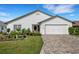 White single-story house with a two-car garage and landscaped front yard at 6250 Sandpipers Dr, Lakeland, FL 33809