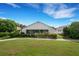 White house back with screened porch, landscaped yard, and walkway at 6250 Sandpipers Dr, Lakeland, FL 33809