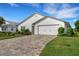 White house front with a two-car garage and landscaped yard at 6250 Sandpipers Dr, Lakeland, FL 33809