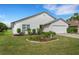 White house front with a two-car garage and landscaped yard at 6250 Sandpipers Dr, Lakeland, FL 33809