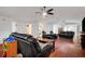 Living room with hardwood floors, ceiling fans, and black leather furniture at 6250 Sandpipers Dr, Lakeland, FL 33809