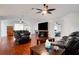 Spacious living room with hardwood floors, fireplace and black leather furniture at 6250 Sandpipers Dr, Lakeland, FL 33809