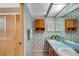 Bathroom with dual sinks, shower, and updated vanity at 6256 Sandpipers Dr, Lakeland, FL 33809