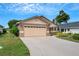 Tan one-story house with two-car garage and well-manicured landscaping at 6256 Sandpipers Dr, Lakeland, FL 33809