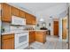 Kitchen with wood cabinets, white appliances, and a breakfast bar at 6256 Sandpipers Dr, Lakeland, FL 33809