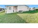 Home features a covered patio and a well maintained lawn at 6461 Hollyberry Ne Ln, Winter Haven, FL 33881