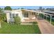 Front exterior view of a manufactured home showcasing its light-colored siding and covered carport at 6461 Hollyberry Ne Ln, Winter Haven, FL 33881