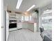Efficient kitchen with white cabinets, pink countertops, and tile flooring at 6461 Hollyberry Ne Ln, Winter Haven, FL 33881
