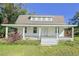White farmhouse with wrap-around porch, gray roof, and mature landscaping at 285 Lemon St, Mulberry, FL 33860