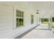 Bright, spacious front porch with white railings and wood flooring at 285 Lemon St, Mulberry, FL 33860