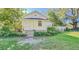 Charming white cottage with a spacious front yard and mature landscaping at 285 Lemon St, Mulberry, FL 33860