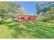 Red metal garage sits on a grassy lot at 285 Lemon St, Mulberry, FL 33860