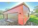 Red metal three-car garage with brown doors at 285 Lemon St, Mulberry, FL 33860