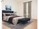 Virtually staged bedroom with a plush bed and bench at 6064 Condor Dr, Lakeland, FL 33809