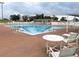 Community pool with lounge chairs and tables at 6064 Condor Dr, Lakeland, FL 33809