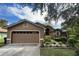 Two-story house with a brown exterior, two-car garage, and landscaping at 737 Butternut Pl, Lakeland, FL 33813
