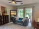 Spacious living area with a gray sofa, large window, and view of the backyard at 737 Butternut Pl, Lakeland, FL 33813