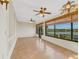 Bright sunroom with lake views, tile flooring, and ceiling fans at 14 Casa Loma Way, Lakeland, FL 33813