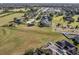 Aerial view of a residential neighborhood, showcasing homes with solar panels and lush green spaces at 1898 Charleston Ln, Bartow, FL 33830