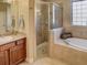 Bathroom features a large soaking tub, walk-in shower, and wood vanity at 1898 Charleston Ln, Bartow, FL 33830
