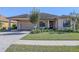 Tan house with brown roof, double garage, and lush landscaping at 1898 Charleston Ln, Bartow, FL 33830