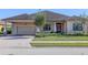 Tan house with brown roof, double garage, and lush landscaping at 1898 Charleston Ln, Bartow, FL 33830