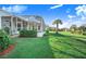 Landscaped backyard with screened patio and water view at 4402 Fairway Oaks Ct, Mulberry, FL 33860