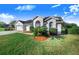 House with a two-car garage, lush landscaping, and palm trees at 4402 Fairway Oaks Ct, Mulberry, FL 33860
