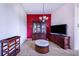 Living Room with a red accent wall, entertainment center and decorative cabinet at 4402 Fairway Oaks Ct, Mulberry, FL 33860