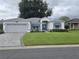 One story house with gray exterior, attached garage, and manicured lawn at 5873 Macaw Pl, Lakeland, FL 33809