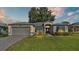 One-story home with gray exterior, attached garage, and landscaped lawn at 5873 Macaw Pl, Lakeland, FL 33809