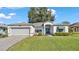 One-story home with gray siding, attached garage, and well-manicured lawn at 5873 Macaw Pl, Lakeland, FL 33809