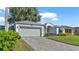 Gray attached garage with driveway and landscaping at 5873 Macaw Pl, Lakeland, FL 33809